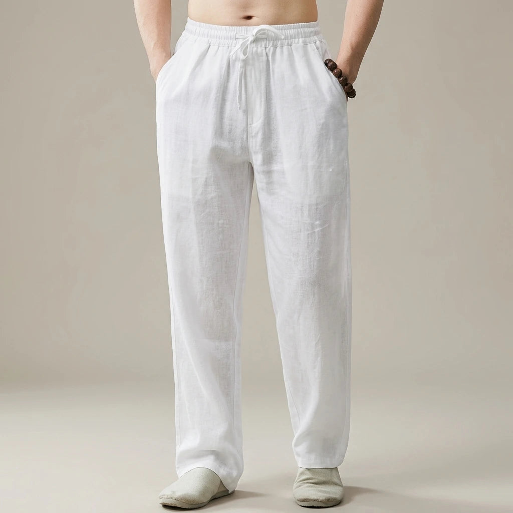 Pantalón Leo - Lino | Replace only the background of this product photo with a seamless warm greige studio backdrop — a soft neutral tone between light taupe and cream, with a subtle